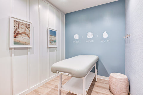 Modern interior with a massage table against a light blue wall.