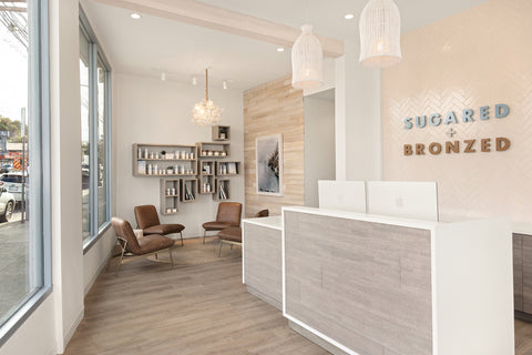 Modern interior of a salon with reception desk and seating area.