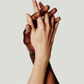 Two hands holding with fingers crossed