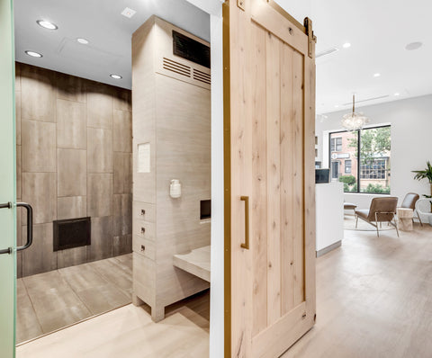 Hallway view of a tanning room with a barn door open and the lobby in the background