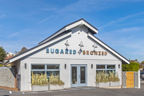 Building with 'Sugared + Bronzed' sign against a blue sky