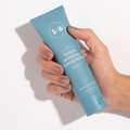 Tinting Mineral Sunscreen being held in a hand with a white background
