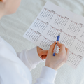 Person holding a pen and looking at a calendar