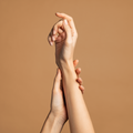 Close-up of two hands on a brown background